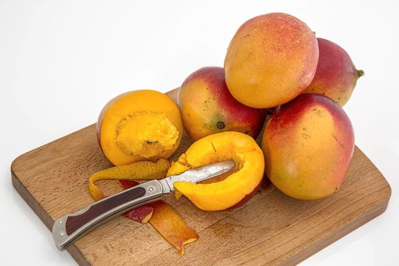 mangoes-on-cutting-board-with-half-cut-mango